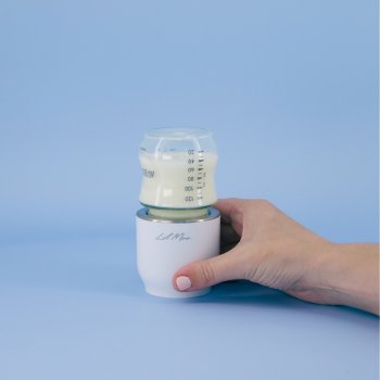 Hand holding a bottle warmer with a blue background