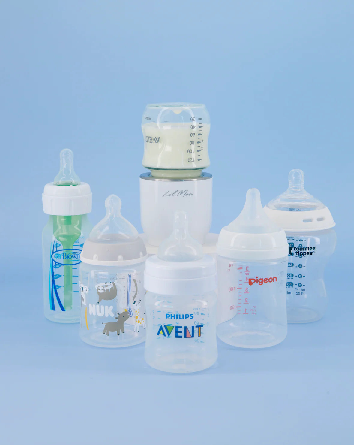 Collection of baby bottles with various brands on a blue background with Lil Moo Bottle Warmer