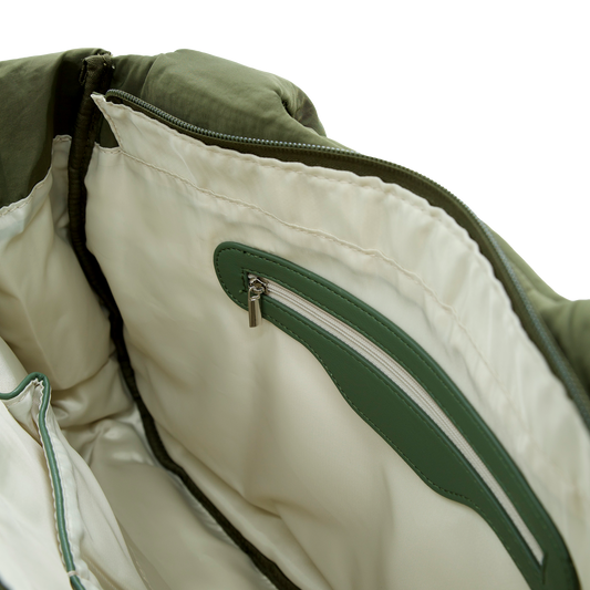 Close-up of a green and beige handbag with a zipper