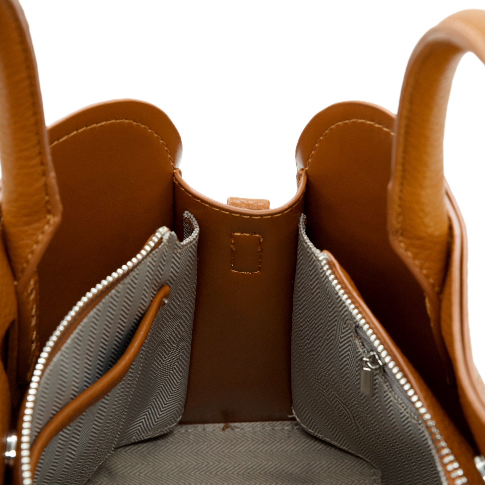 Close-up of a brown vegan leather handbag with a zipper pocket on a white background