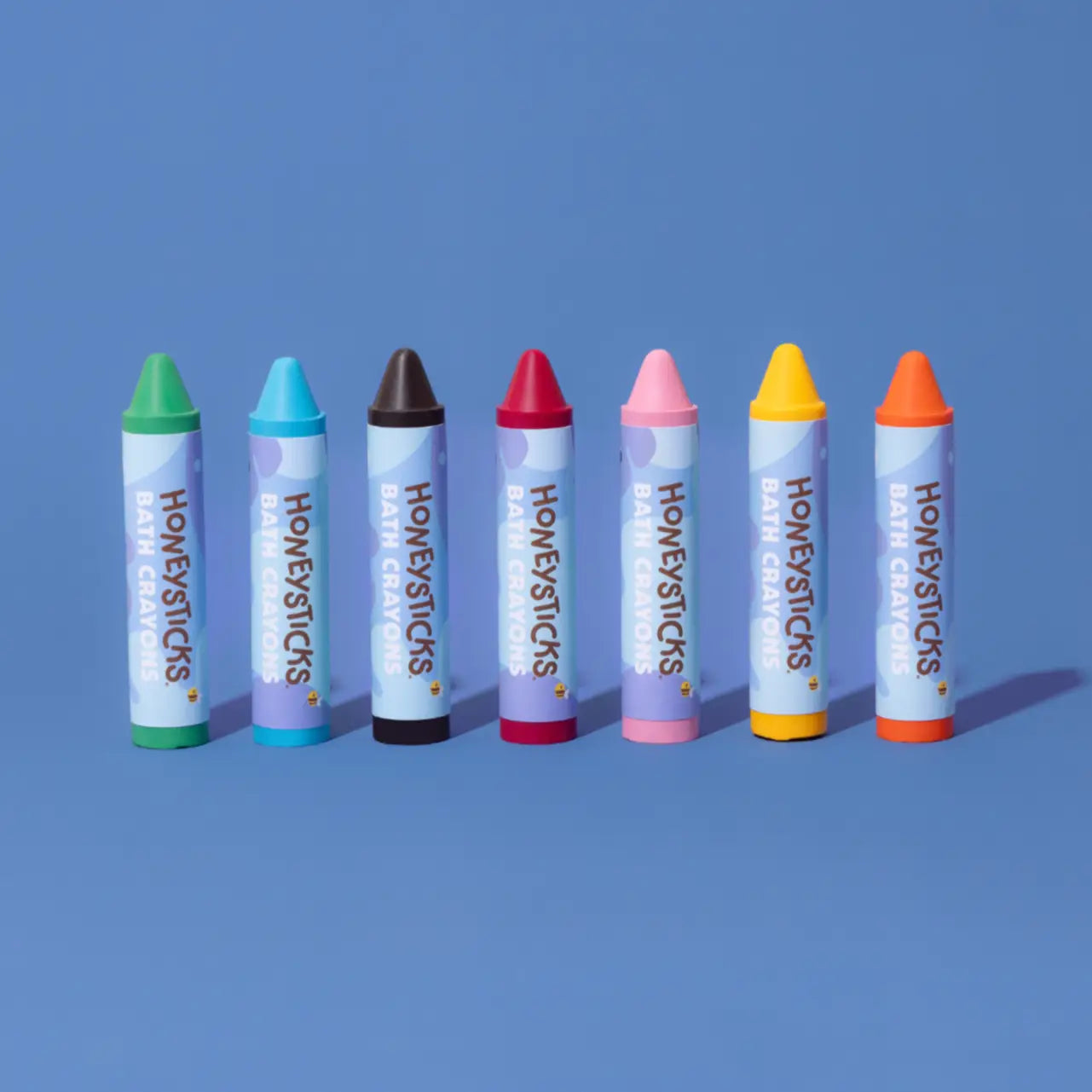 Set of colorful Honeysticks bath crayons on a blue background