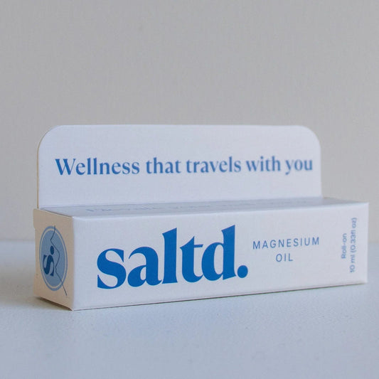 Box of saltd magnesium oil with 'Wellness that travels with you' text on a gray background